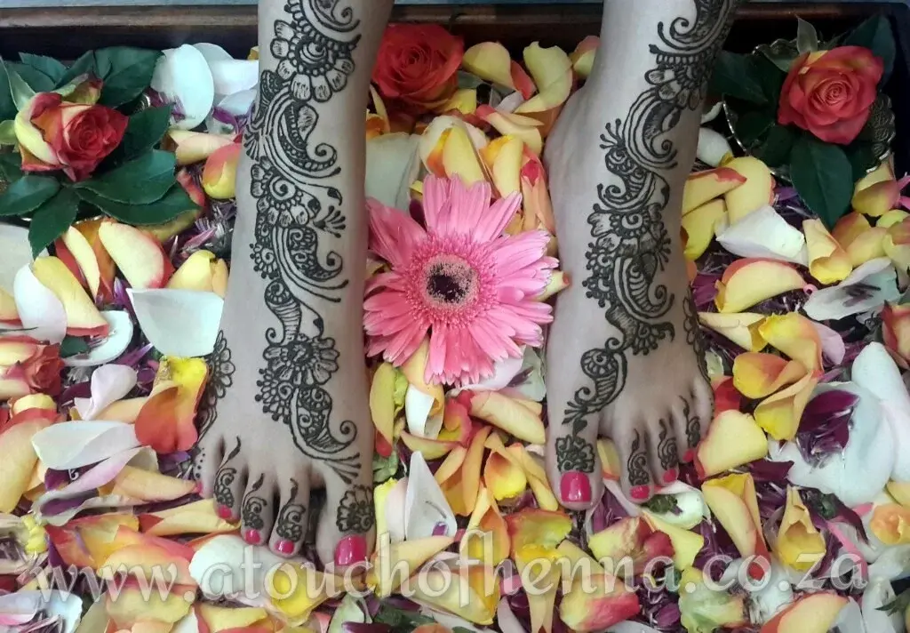 Full-arm bridal mehndi with dense floral and medallion patterns covering hands to forearms, professional photography